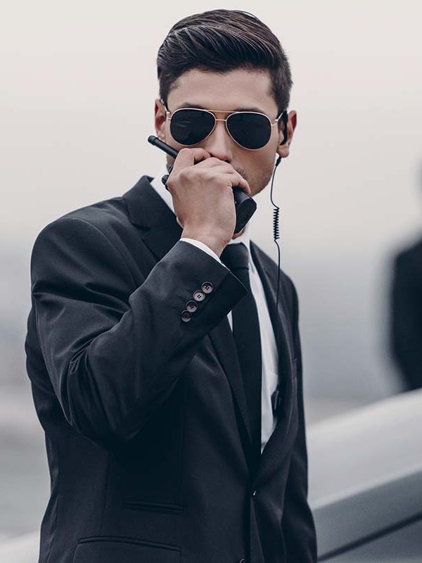 handsome-bodyguard-in-sunglasses-talking-by-portab-P88D8US.jpg