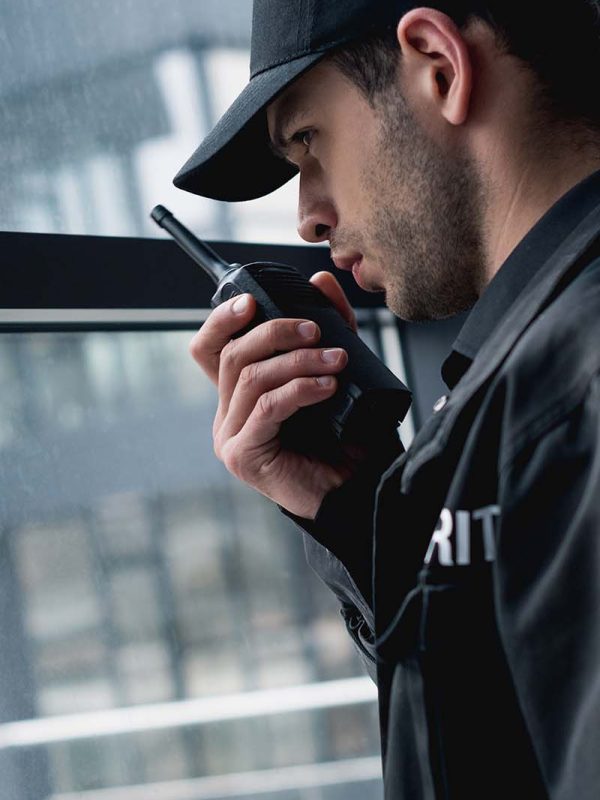 handsome-guard-in-black-uniform-talking-on-walkie-GDJCVQ4.jpg